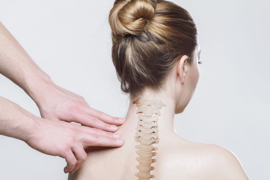 Chiropractor's hands gently examining a woman's cervical spine and neck, with anatomical overlay highlighting the vertebrae, illustrating cervical instability and natural relief options at ChiroCure Health Center