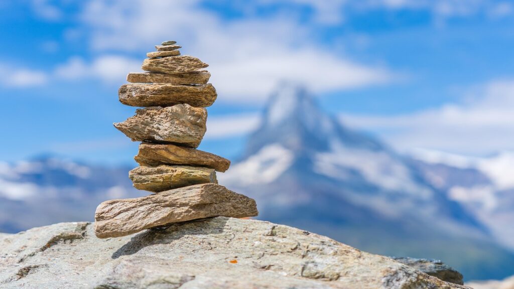 Perfectly balanced stack of rocks on a mountain peak, symbolizing postural alignment and how improving posture transforms health at ChiroCure Health Center